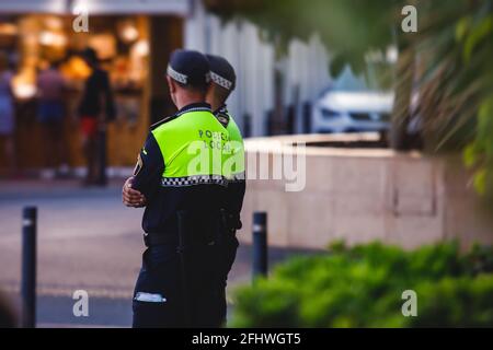 Spanische Polizeieinheit, Rückansicht mit Logo der lokalen Polizei auf Uniform, Aufrechterhaltung der öffentlichen Ordnung in den Straßen von Alicante, Spanien Stockfoto
