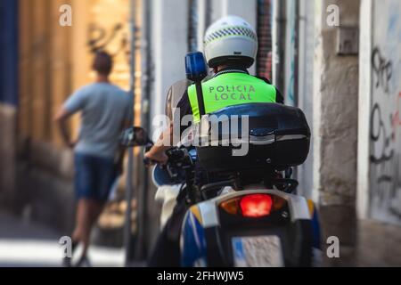 Spanische Polizeigruppe Formation auf Fahrrad und Motorrad Rückansicht Mit dem Logo „Local Police“ auf Uniform, um die öffentliche Ordnung zu erhalten In den Straßen von Ali Stockfoto