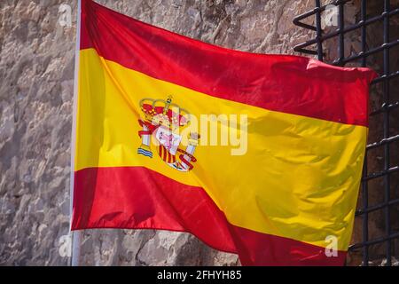 Schwenkende Flagge Spaniens hängt an den Institutionen und Verwaltungsgebäude des Königreichs Spanien in Alicante, Valencia, Spanien Stockfoto