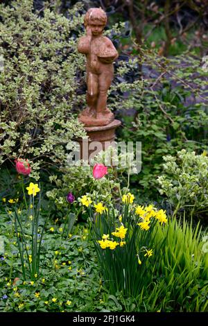 Gelbe Narzissen, Frühlingsanzeige, Frühling im Garten, Statue, Figur, Herzstück, rote Tulpe, Tulpen, Narzissen und Tulpen, rote und Gelbe Frühlingsblumen, R Stockfoto