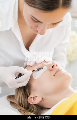 Die Frau hat ihre Wimpern verdickt und verlängert Stockfoto