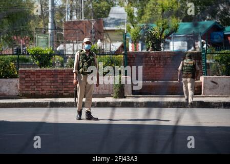 Srinagar, Indien. April 2021. Ein indischer Polizist, der eine Gesichtsmaske trägt, sieht zu, als er während einer Ausgangssperre eines Tages auf der Wache steht, um die Ausbreitung von COVID-19 in Srinagar einzudämmen.Indien hat in den vergangenen 24 Stunden 346,786 neue Fälle von COVID-19 gemeldet, mit 2,624 Todesfällen, Die weltweit höchste Tagesrate seit Beginn der Pandemie im vergangenen Jahr. Insgesamt sind in dem Land fast 190,000 Menschen an COVID gestorben, während mehr als 16.6 Millionen Menschen infiziert wurden. Kredit: SOPA Images Limited/Alamy Live Nachrichten Stockfoto