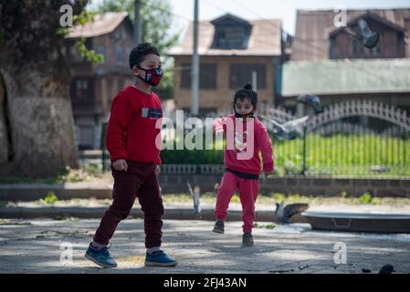 Srinagar, Indien. April 2021. Kinder, die Gesichtsmasken tragen, spielen während einer Ausgangssperre an einem Tag, um die Ausbreitung von COVID-19 in Srinagar einzudämmen.Indien hat in den vergangenen 24 Stunden 346,786 neue Fälle von COVID-19 gemeldet, mit 2,624 Todesfällen, der weltweit höchsten Tagesrate seit Beginn der Pandemie im vergangenen Jahr. Insgesamt sind in dem Land fast 190,000 Menschen an COVID gestorben, während mehr als 16.6 Millionen Menschen infiziert wurden. Kredit: SOPA Images Limited/Alamy Live Nachrichten Stockfoto