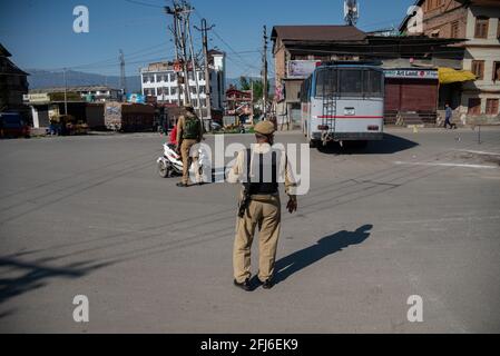 Srinagar, Indien. April 2021. Indische Polizisten stehen während einer eintägigen Ausgangssperre auf einer verlassenen Straße auf der Wache, um die Ausbreitung von COVID-19 in Srinagar einzudämmen.Indien hat in den vergangenen 24 Stunden 346,786 neue Fälle von COVID-19 gemeldet, mit 2,624 Todesfällen, der weltweit höchsten täglichen Zahl seit Beginn der Pandemie im vergangenen Jahr. Insgesamt sind in dem Land fast 190,000 Menschen an COVID gestorben, während mehr als 16.6 Millionen Menschen infiziert wurden. (Foto von Idrees Abbas/SOPA Images/Sipa USA) Quelle: SIPA USA/Alamy Live News Stockfoto