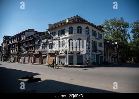 Srinagar, Indien. April 2021. Ein Mann mit einem Fahrrad geht während einer Ausgangssperre einen Tag lang auf einer verlassenen Straße entlang, um die Ausbreitung von COVID-19 in Srinagar einzudämmen.Indien hat in den vergangenen 24 Stunden 346,786 neue Fälle von COVID-19 gemeldet, mit 2,624 Todesfällen, der weltweit höchsten Tagesrate seit Beginn der Pandemie im vergangenen Jahr. Insgesamt sind in dem Land fast 190,000 Menschen an COVID gestorben, während mehr als 16.6 Millionen Menschen infiziert wurden. (Foto von Idrees Abbas/SOPA Images/Sipa USA) Quelle: SIPA USA/Alamy Live News Stockfoto