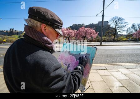 Edinburgh, Schottland, Großbritannien. 25. April 2021. Szenen aus den Straßen des Stadtzentrums von Edinburgh am Sonntagnachmittag am Tag, bevor nicht unbedingt erforderliche Geschäfte und Unternehmen in Schottland unter entspannten Covid-19-Sperrregeln wieder eröffnet werden können. PIC ein Künstler, der Kirschblüte auf der Princes Street malt. Iain Masterton/Alamy Live News Stockfoto