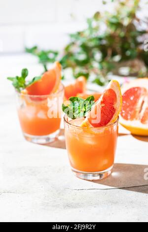 Kalter Cocktail aus zerkleinertem Eis mit einer Scheibe Grapefruit auf hellgrauem Betongrund. Erfrischendes Getränk mit Eis. Alkohol- oder nicht-alkoholischer Cocktail Stockfoto
