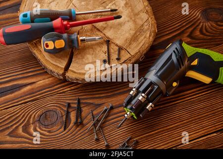 Schraubendreher und selbstschneidende Schrauben am Stumpf Stockfoto