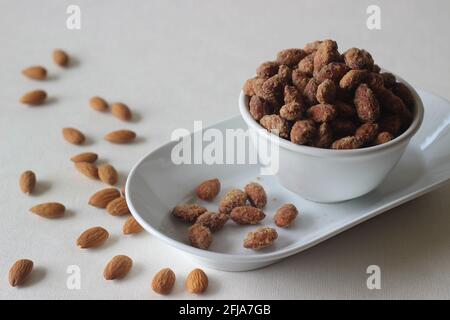 Kandierte Mandeln, die knusprig und goldbraun sind. Aufgenommen auf weißem Hintergrund. Stockfoto