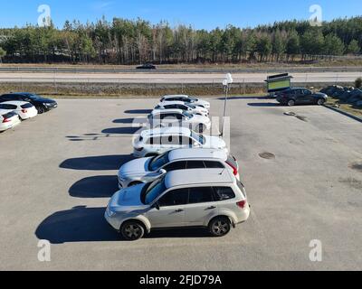 Schöne Aussicht auf Fahrzeuge auf Parkplatz auf grünen Waldbäumen und blauen Himmel Hintergrund. Schweden. Stockfoto