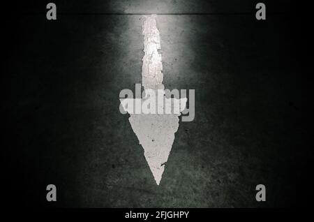 Parkschild mit weißem Pfeil. Dunkler Hintergrund Stockfoto