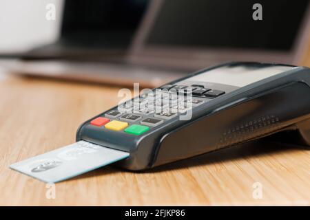 POS-Terminal mit Kreditkarte auf dem Holzschreibtisch. Stockfoto