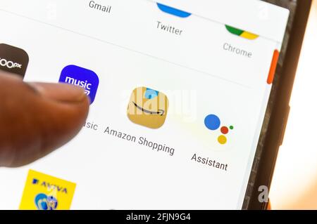 Amazon-Shopping-Symbol auf dem Smartphone, das von einem erwachsenen Mann bedient wird Stockfoto