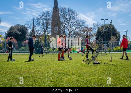 Jugendliche, die nach der Lockerung der Covid-19-Sperrbeschränkungen am Outdoor-Mannschaftssport teilnehmen. Stockfoto