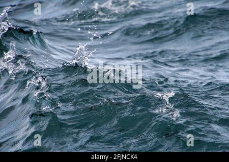 Nahaufnahme des welligen Seewassers mit Spritzer Tröpfchen Stockfoto