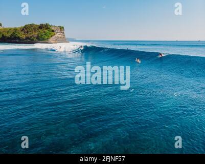 Luftaufnahme mit Surfen auf idealer Barrel-Welle. Blaue perfekte Wellen und Surfer im Ozean Stockfoto