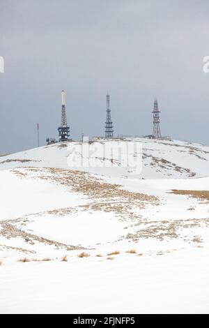 Drei Sendetürme auf einem verschneiten Hügel Stockfoto