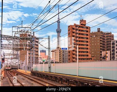 tokio, japan - 25 2021. april: Tobu Isesaki Line-Zug, der die Eisenbahn des Kanegafuchi-Bahnhofs mit dem höchsten Turm Tokyos, dem Skytree in BA, passiert Stockfoto