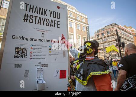 24. April 2021, London, England, Vereinigtes Königreich: Ein Mann, der ein Kostüm mit Pestmaske trägt und auf das Stay Save-Zeichen zeigt, als er an einem Anti-Lock teilnimmt Stockfoto