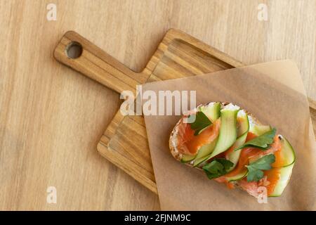 Appetitliches Bruschetta-Sandwich aus Vollkornbrot, mit rotem Fisch und Quark, mit dünn geschnittenem ​​cucumber. Konzept der gesunden Ernährung, hea Stockfoto