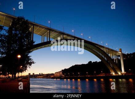 Sonnenuntergang auf der modernen Arrabida-Brücke (Ponte da Arrábida), die den Douro-Fluss in Porto, Portugal, überquert. Stockfoto
