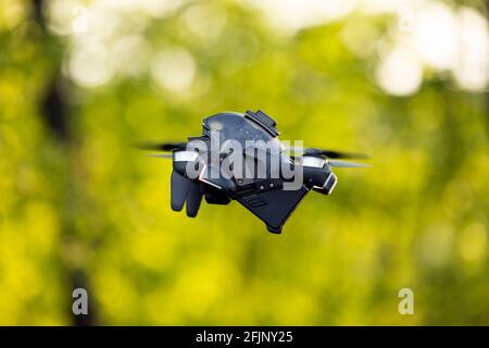 Atemberaubende Aussicht auf eine FPV-Drohne, die während eines wunderschönen Sonnenuntergangs über einem Grasfeld fliegt. Konzept der Freizeitbeschäftigungen, Hobby. Stockfoto