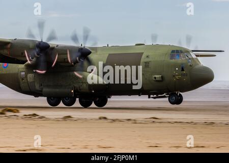 PEMBREY, WALES - APRIL 13 2021: Eine Royal Air Force Lockheed C-130J 'Super Hercules', die taktische Landungen und Starts vom öffentlichen Strand aus durchführt Stockfoto