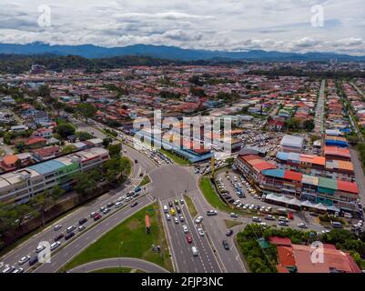 Luftdrohne-Bild eines Autos, das sich in einem Wohngebiet in Kota Kinabalu, Sabah, Malaysia, bewegt Stockfoto