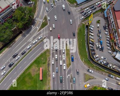 Luftdrohne-Bild eines Autos, das sich in einem Wohngebiet in Kota Kinabalu, Sabah, Malaysia, bewegt Stockfoto