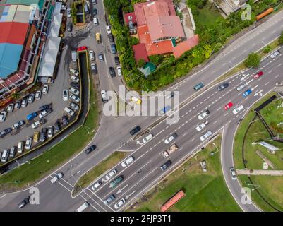 Luftdrohne-Bild eines Autos, das sich in einem Wohngebiet in Kota Kinabalu, Sabah, Malaysia, bewegt Stockfoto