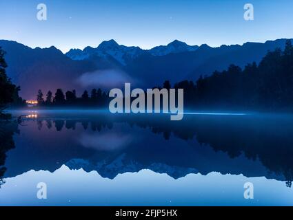 Blick auf Mount Cook und Mount Tasman bei Sonnenaufgang, Spiegelung im Lake Matheson, Westland National Park, Neuseeland Alps, West Coast Region, South Stockfoto