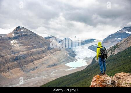 Wanderer, der auf Felsen steht und das Tal mit Gletscherzunge überblickt, Parker Ridge, Saskatchewan Glacier, Athabasca Glacier, Jasper National Park National Stockfoto