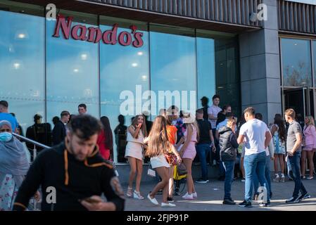 Vereinigtes Königreich Wetter: Birmingham, Vereinigtes Königreich. 25. April 2021: Eine Gruppe von Mädchen wartet auf Nandos, als die Sonne am Sonntag in Großbritannien aufging. Kredit: Ryan Underwood / Alamy Live Nachrichten Stockfoto