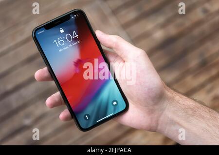 Hand haelt iPhone 11 Pro mit Lockscreen, Smartphone Stockfoto