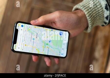 Hand haelt iPhone 11 Pro mit Google Maps App, Online Karten Dienst, Bildschirmfoto, Smartphone Stockfoto