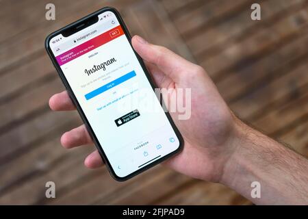 Hand haelt iPhone 11 Pro mit geoeffneter Instagram Website, Login, Soziales Netzwerk, Logo, Smartphone Stockfoto