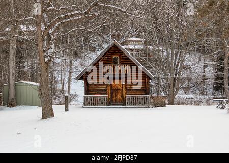 Ein Gartenschuppen, der wie eine Blockhütte aussieht - Winterschneeszene Stockfoto