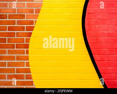 Backsteinmauer Hintergrund mit gelb und rot bemalt. Leerer Raum auf lebendiger Ziegelsteinwand-Textur. Stockfoto