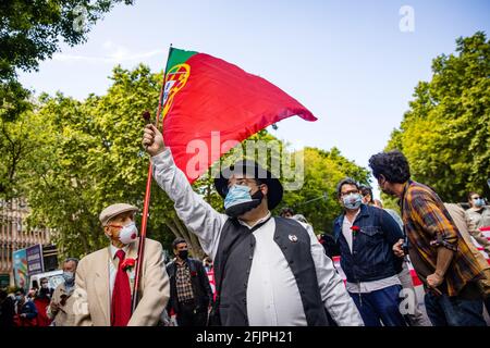 Lissabon, Portugal. April 2021. Ein Mann, der als "Zé Povino" gekleidet war, sah während des Jahrestages eine rote Nelke in der Hand halten.1 Jahr nach Beginn der Pandemie genehmigte die portugiesische Regierung die Feier des 47. Jahrestages der Revolution vom 25. April, auch bekannt als die Nelkenrevolution. Kredit: SOPA Images Limited/Alamy Live Nachrichten Stockfoto