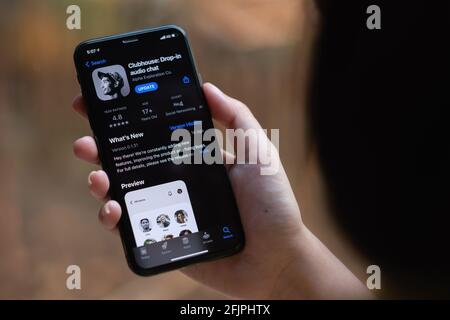 CHIANG MAI, THAILAND, 13 MAR 2021 : Frau in kabelgebundenen Kopfhörern hält Smartphone mit Clubhouse Drop in Audio-Chat-Anwendung auf dem Bildschirm. Neue soziale Netzwerke Stockfoto