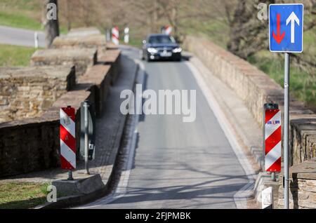 21. April 2021, Sachsen, Halsbrücke: Die mehr als 500 Jahre alte Oldfathers' Bridge überspannt die Freiberg Mulde zwischen Rothenfurth und Halsbrücke. An dieser steinernen Bogenbrücke wurde Ende des 17. Jahrhunderts ein Aquädukt errichtet, das die nahe gelegene Silbererzmine „St.“ versorgte Anna' mit Wasserkraft über einen Kilometer langen künstlichen Graben. Das Aquädukt wurde 1893 wegen Verfall abgerissen und die Säulen wurden gesprengt. In den 1990er Jahren wurde die steinerne Bogenbrücke renoviert. Aufgrund seiner Geschichte ist die Straße jedoch nur 2.85 Meter breit. Foto: Jan Woitas/dpa-Zentralbild/ZB Stockfoto