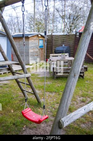 Pepelow, Deutschland. April 2021. Auf einem Spielplatz auf dem Gelände des Ostseecampfs 'am Salzhaff' hängt eine leere Kinderschaukel. Aufgrund der Corona-Schutzmaßnahmen sind die Campingplätze in Mecklenburg-Vorpommern derzeit geschlossen, auch Dauercamper dürfen nicht in ihren Wohnwagen oder Zelten übernachten. Quelle: Jens Büttner/dpa-Zentralbild/dpa/Alamy Live News Stockfoto