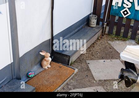 Fehmarn, Deutschland. April 2021. Ein Osterhase aus Porzellan steht am Eingang einer Markise auf einem Campingplatz. Hotels und Pensionen sind geschlossen, auch mit dem Wohnmobil ist Urlaub kaum möglich. Glücklich, wer ein dauerhafter Camper in der Corona-Pandemie ist. Quelle: Frank Molter/dpa/Alamy Live News Stockfoto