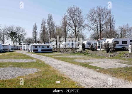 Fehmarn, Deutschland. April 2021. Mietwohnwagen stehen auf einem Campingplatz hinter leeren Stellplätzen. Hotels und Pensionen sind geschlossen, auch mit dem Wohnmobil ist Urlaub kaum möglich. Glücklich, wer ein dauerhafter Camper in der Corona-Pandemie ist. Quelle: Frank Molter/dpa/Alamy Live News Stockfoto