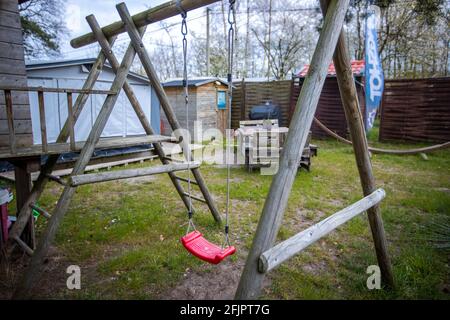 Pepelow, Deutschland. April 2021. Auf einem Spielplatz auf dem Gelände des Ostseecampfs 'am Salzhaff' hängt eine leere Kinderschaukel. Aufgrund der Corona-Schutzmaßnahmen sind die Campingplätze in Mecklenburg-Vorpommern derzeit geschlossen, auch Dauercamper dürfen nicht in ihren Wohnwagen oder Zelten übernachten. Quelle: Jens Büttner/dpa-Zentralbild/dpa/Alamy Live News Stockfoto