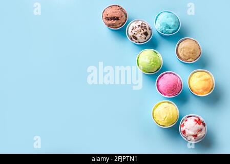 Eiscreme-Sortiment. Verschiedene Eiscreme oder Eis auf blauem Hintergrund, Platz kopieren. Gefrorener Joghurt in kleinen Tassen - gesundes Sommerdessert. Stockfoto