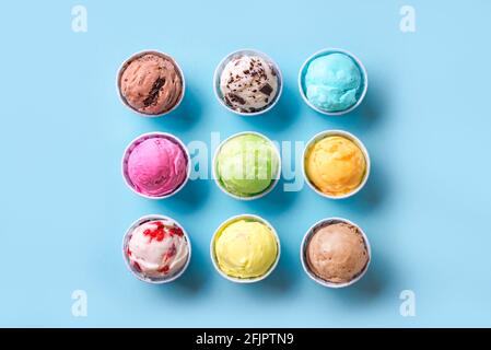 Eiscreme-Sortiment. Verschiedene Eiscreme oder Eis auf blauem Hintergrund, Draufsicht. Gefrorener Joghurt in kleinen Tassen - gesundes Sommerdessert. Stockfoto