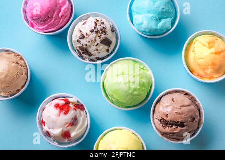 Eiscreme-Sortiment. Verschiedene Eiscreme oder italienisches Eis auf blauem Hintergrund, Nahaufnahme. Gefrorener Joghurt in kleinen Tassen - gesundes Sommerdessert. Stockfoto