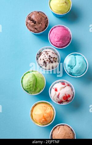 Eiscreme-Sortiment. Verschiedene Eiscreme oder Eis auf blauem Hintergrund, Draufsicht. Gefrorener Joghurt in kleinen Tassen - gesundes Sommerdessert. Stockfoto