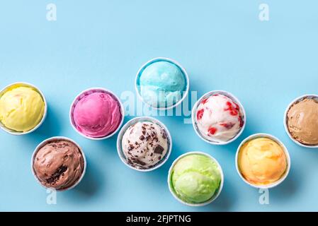 Eiscreme-Sortiment. Verschiedene Eiscreme oder italienisches Eis auf blauem Hintergrund, Kopierraum. Gefrorener Joghurt in kleinen Tassen - gesundes Sommerdessert. Stockfoto